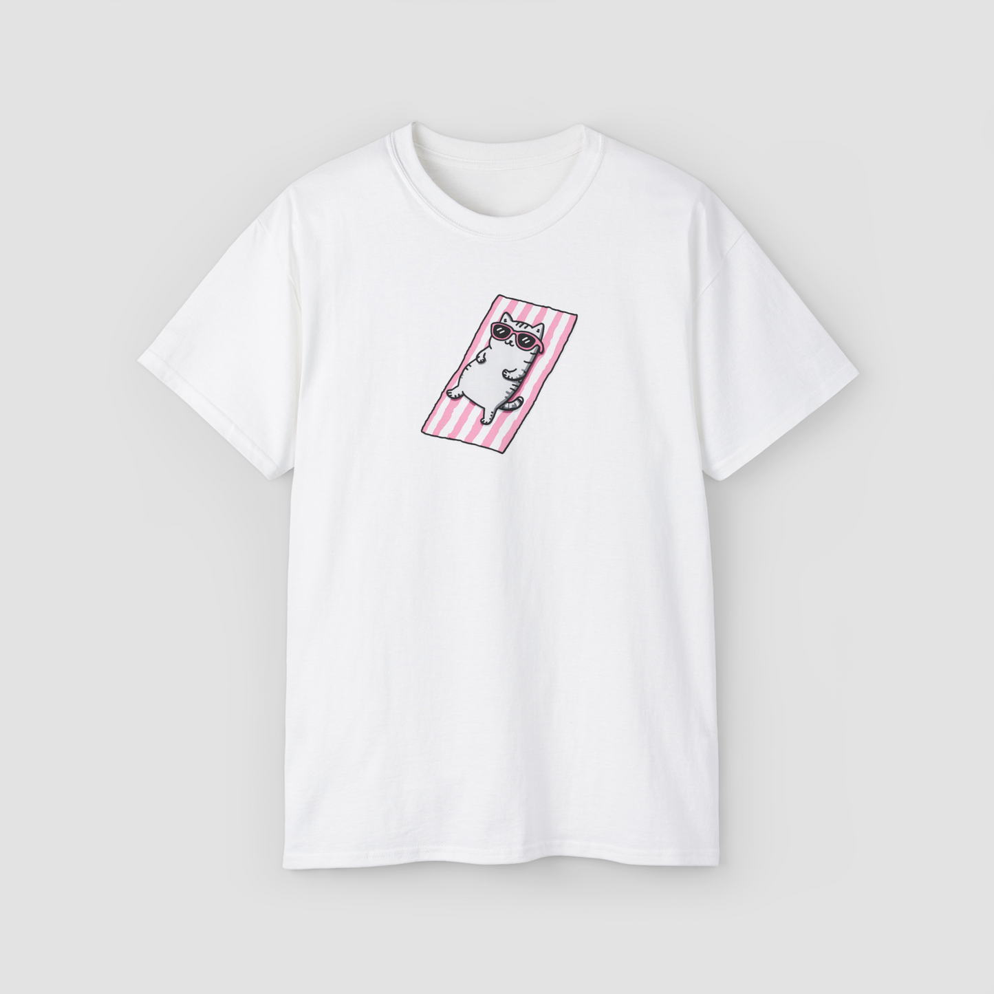 A cute cat in sunglasses lounging on a beach towel, 'I'm a Beach Cat' white oversized t-shirt.\